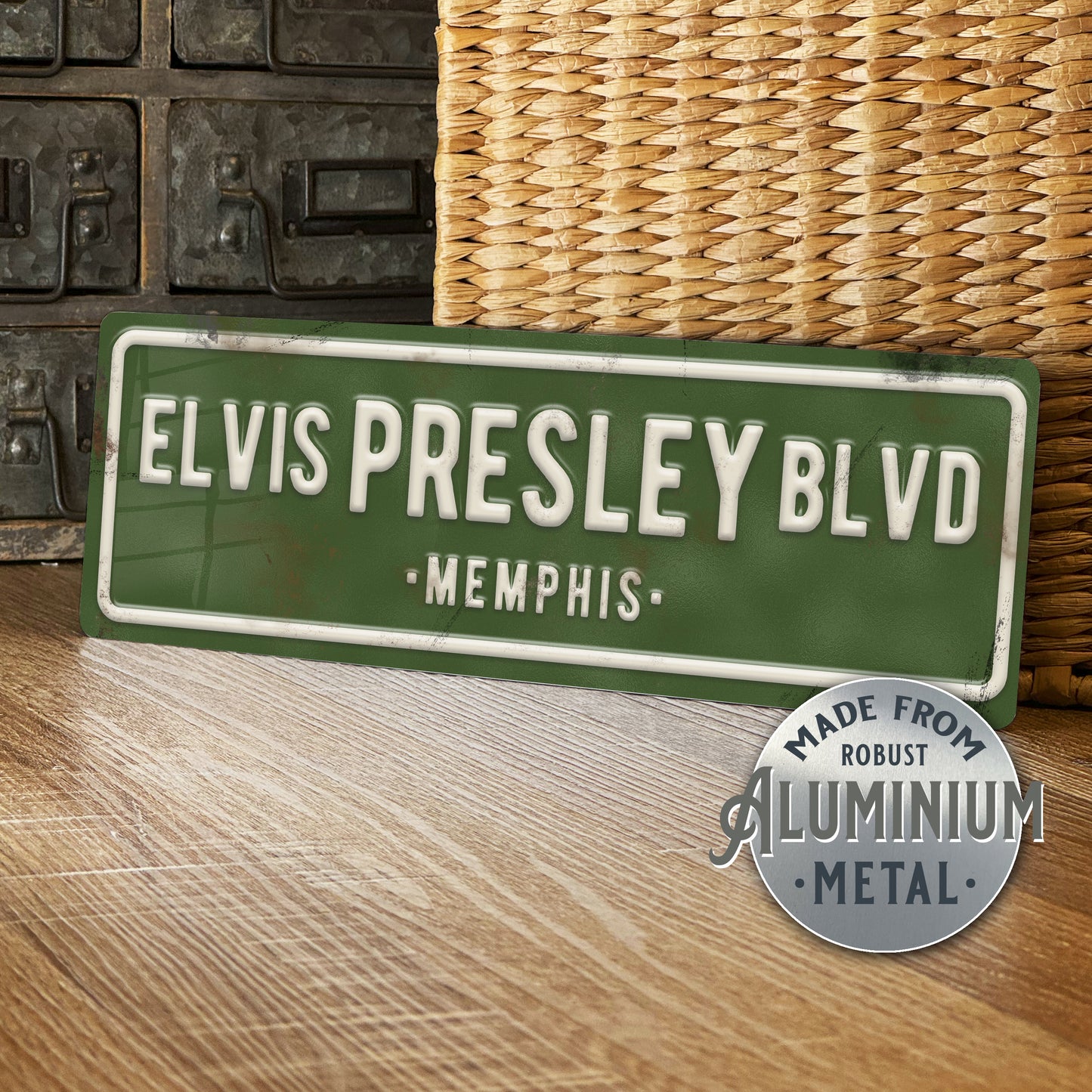 Green street sign with 'Elvis Presley Blvd, Memphis' text on a wooden surface.