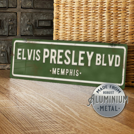 Green street sign with 'Elvis Presley Blvd, Memphis' text on a wooden surface.
