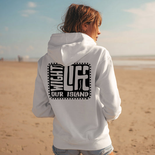 Person wearing a white hoodie with text on the back, standing on a beach.