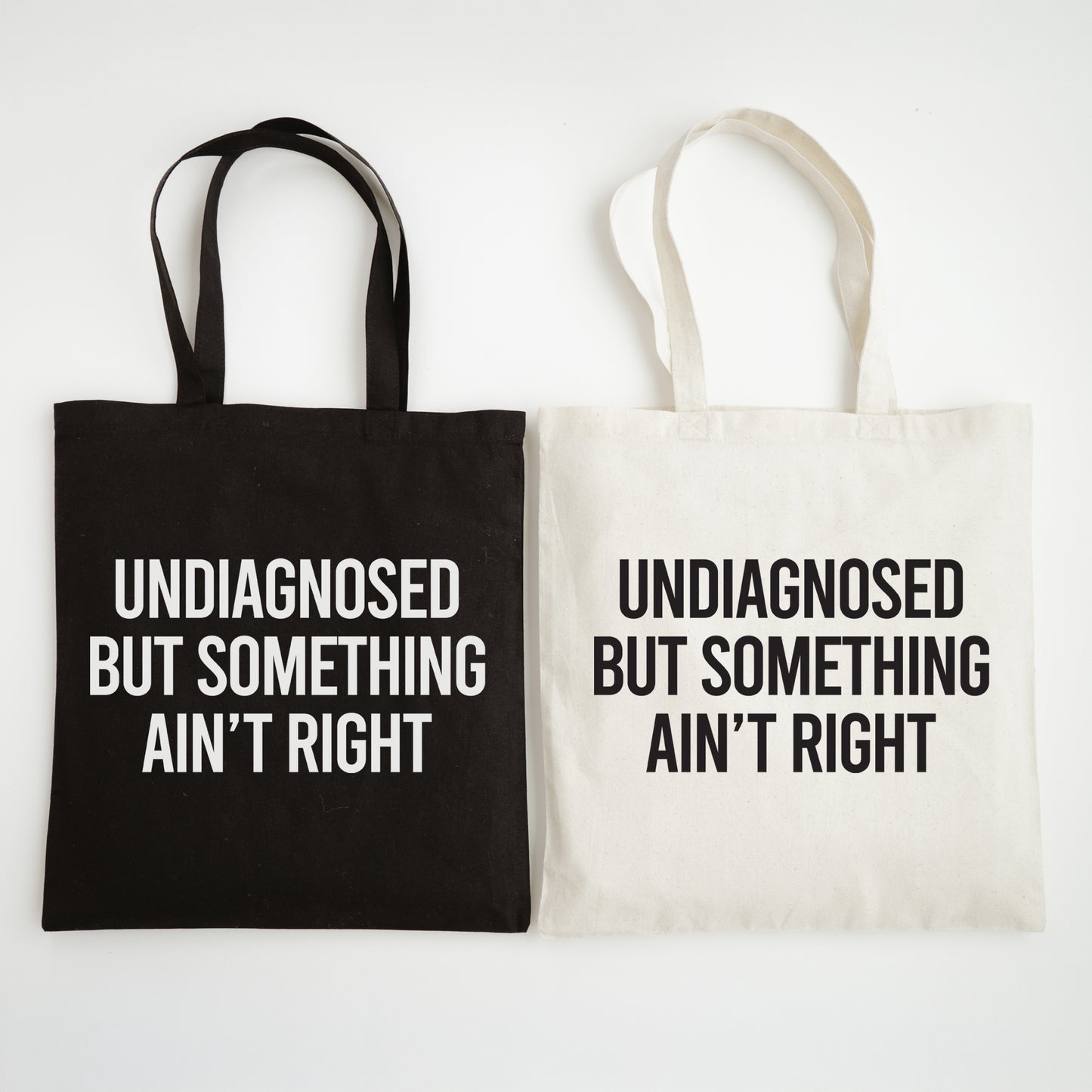 Black and white tote bags with text on a white background
