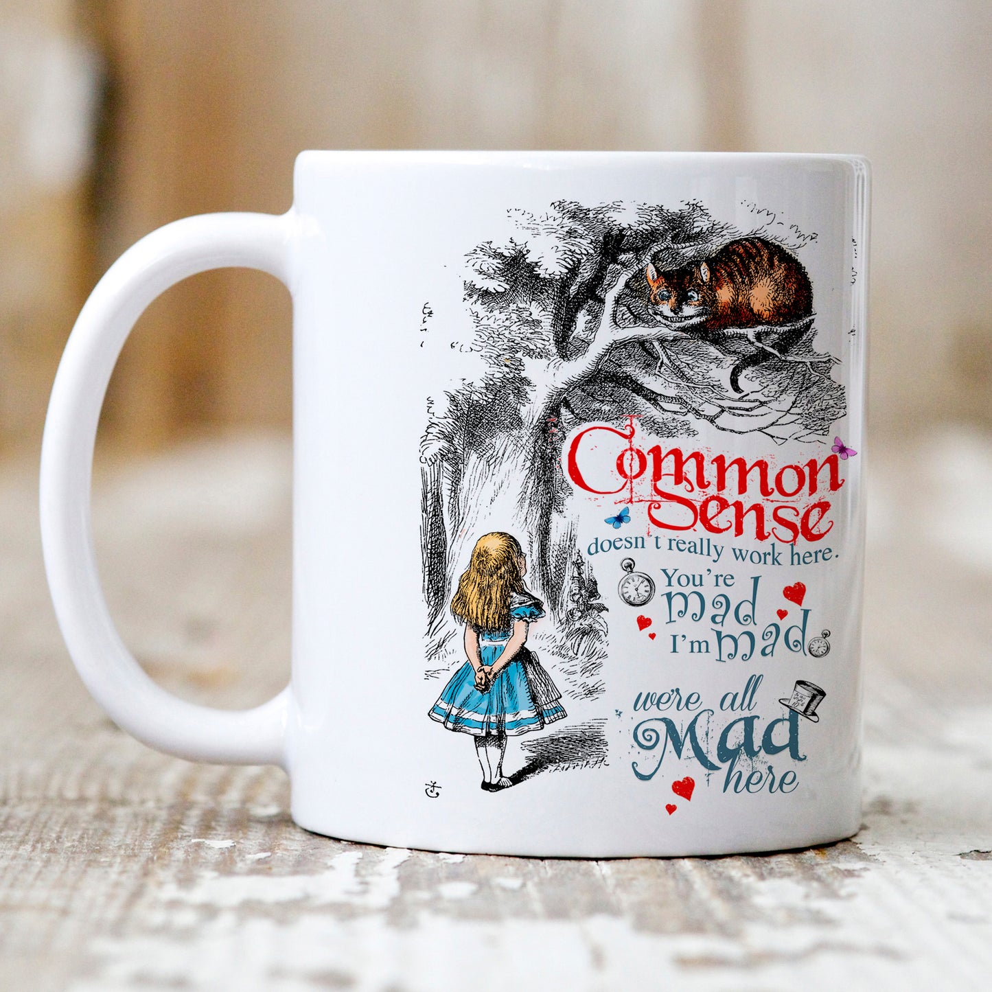 Alice in Wonderland Mug gift depicting Alice and the Cheshire Cat with the phrase 'Common Sense doesn't really work here. You're mad, I'm Mad, We're all mad here'