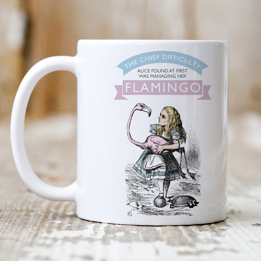 Alice in Wonderland Gift Mug depicting Alice holding a Flamingo and the Phrase 'The chief difficulty Alice found at first was managing her Flamingo'