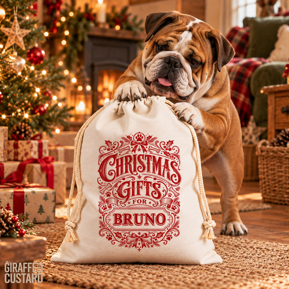 A bulldog stands behind a cream drawstring gift bag printed with red decorative text reading 'Christmas Gifts for Bruno.' The scene is a cozy Christmas living room with a lit tree, fireplace, wrapped gifts, and plaid textiles in the background.