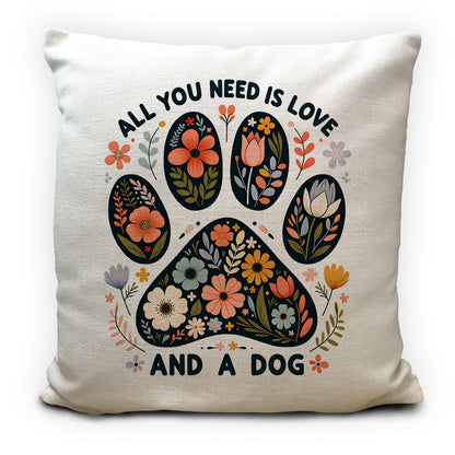 Pillow with paw print design and text 'All you need is love and a dog' on a white background