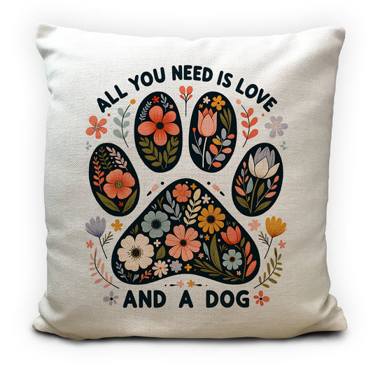 Pillow with paw print design and text 'All you need is love and a dog' on a white background