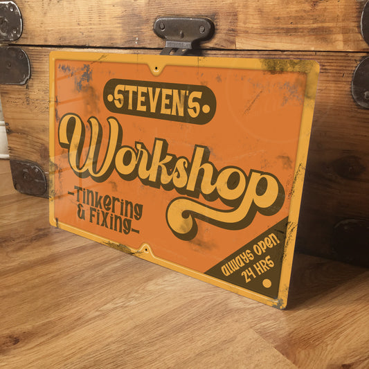 Vintage-style sign reading 'Steven's Workshop' on a wooden surface