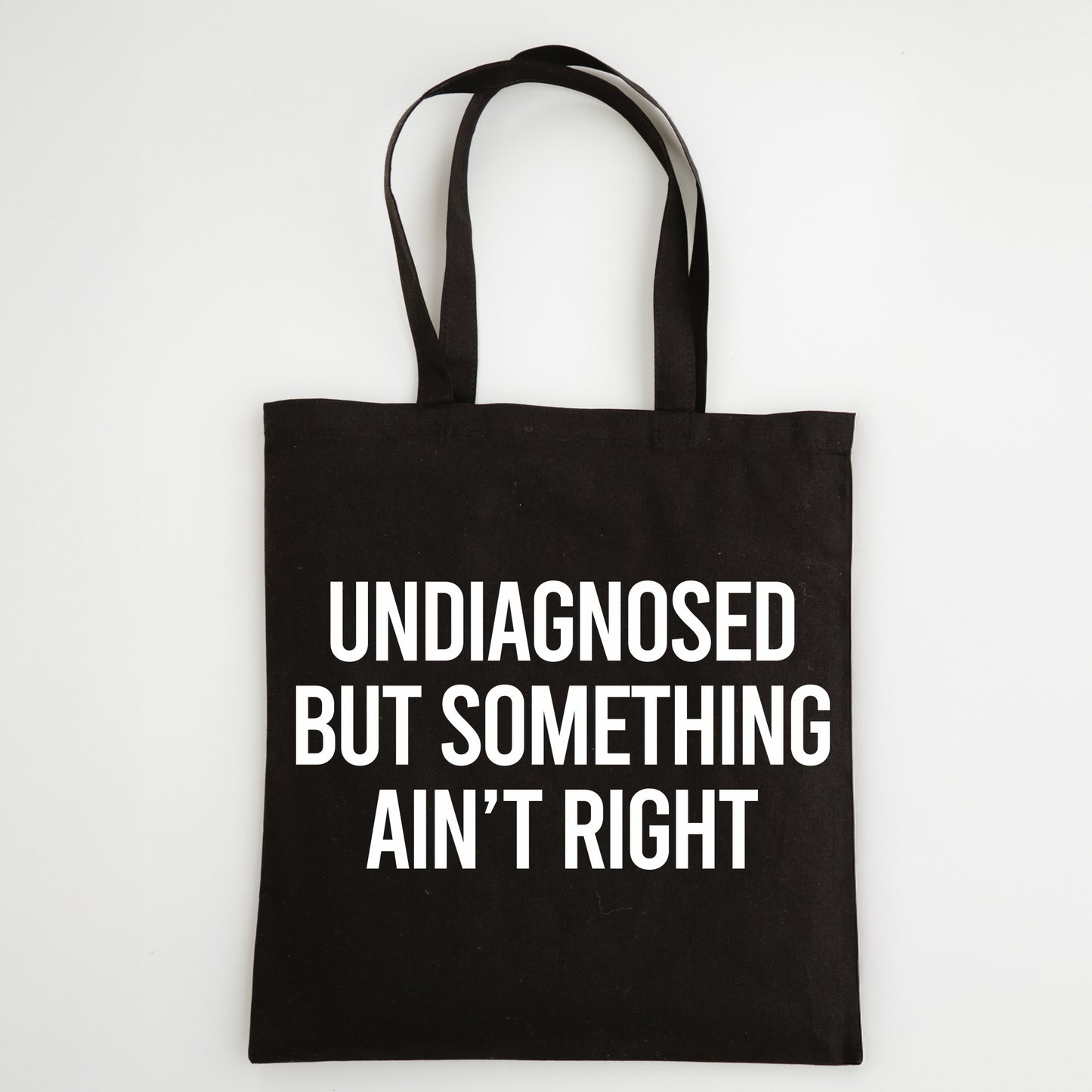 Funny Slogan Tote Bag – “Undiagnosed but Something Ain't Right”