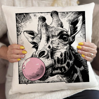 Pillow with a giraffe illustration blowing a pink bubble, held by a person.
