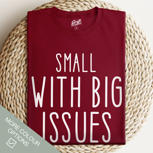 Maroon t-shirt with 'Small with Big Issues' text on a woven surface