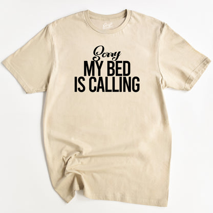Beige t-shirt with 'Sorry My Bed Is Calling' text on a white background